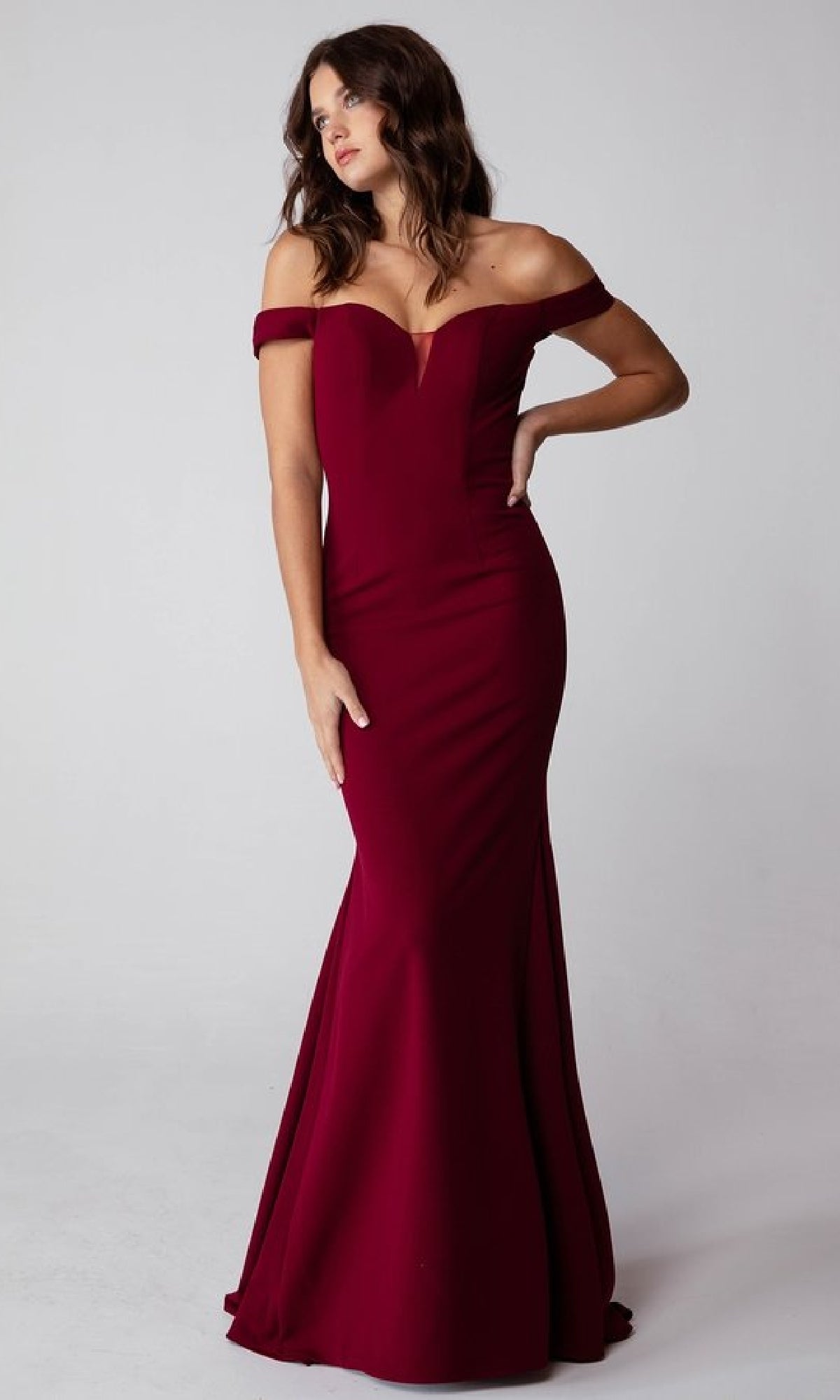 A woman models the Off-Shoulder Long Jersey Prom Dress, Eureka 9081, featuring a fitted mermaid skirt, against a plain light background.